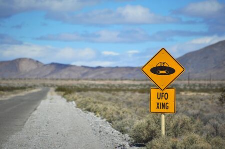 A comical traffic sign in the desert warning of UFO crossingの写真素材