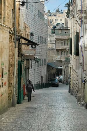 A solitary Palestinian boy walks in an alley in the old city of Jerusalemの写真素材