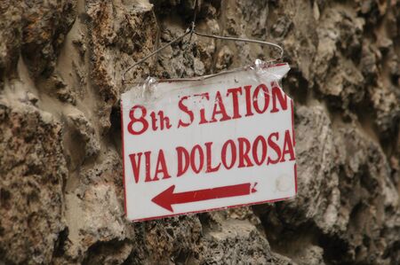 A lowly sign, hung with a wire hanger, marks the 8th Station of the Cross, Via Dolorosaの写真素材