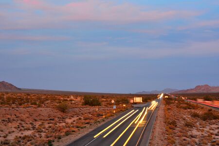 Truckers leaving streaks of light on Interstate 10 headed eastbound toward Joshua Tree at duskの写真素材