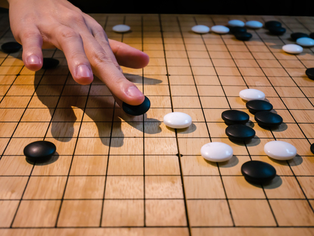 close up of player hand make a move in Go game(Weiqi),Traditional asian strategy board gameの写真素材