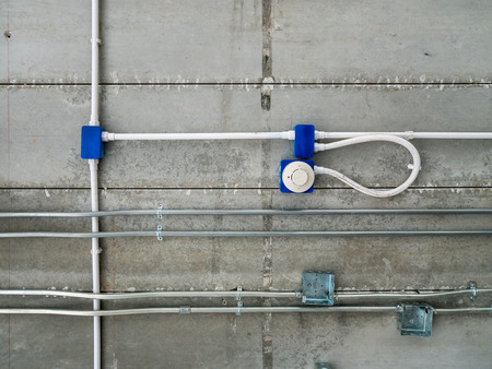 Electric wire and fire alarm on the raw concrete ceiling,detail of construction,system buildingの写真素材