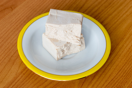 Baker compressed fresh yeast on plate.の写真素材