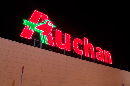 Gdansk, Poland - December 2, 2017: Illuminated Auchan logo at supermarket in Gdansk. Auchan is international supermarket chain.のeditorial素材
