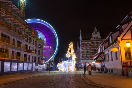 Gdansk, Poland - December 9, 2017: Gifts and crane as christmas decorations with ferris wheel in background.のeditorial素材