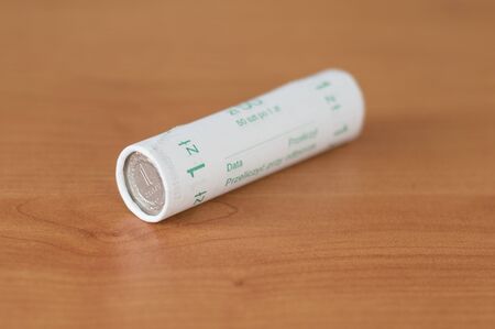 Pack of 50 1 zloty coins on wooden table.の写真素材