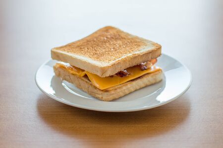 Toast with cheese and bacon on white plate.の写真素材