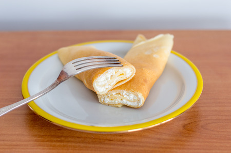 Traditional Polish pancake is known as nalezniki with white cheese and fork.の写真素材