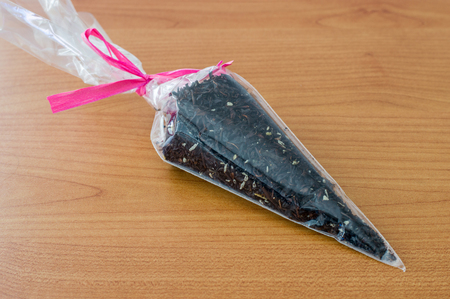 Dry tea in plastic bag on wooden table.の写真素材