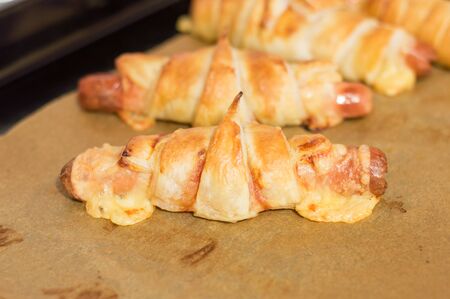 Baked wrapped sausage with cheese, ketchup in puff pastry.の写真素材