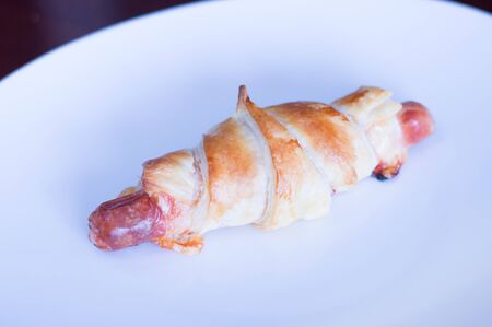 Baked wrapped sausage with cheese, ketchup in puff pastry.の写真素材