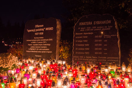 Gdansk, Poland - November 1, 2018: Candles at memorial plaque dedicated to the victims of Polish Operation of the NKVD and memorial plaque dedicated to the Sybiraks at Gdansk Lostowice cemetery.のeditorial素材
