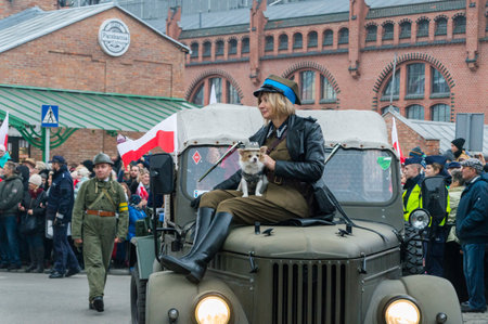 Gdansk, Poland - November 11, 2018: Woman in historical soldier uniform with dog on the car. On the 11 November 2018 is the 100th anniversary of regaining independence by Poland.のeditorial素材