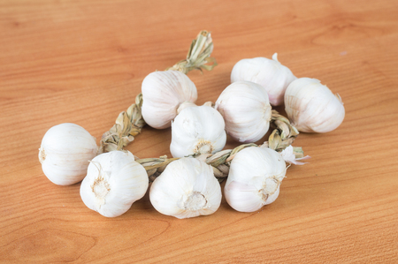Polish garlic bulbs at wooden table.の写真素材