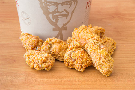 Pruszcz Gdanski, Poland - August 23, 2018: Fried chicken Hot Wings next to bucket. KFC Hot Wings fried chicken.のeditorial素材