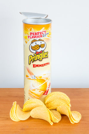 Pruszcz Gdanski, Poland - January 4, 2019: Open tube of Pringles chips with Pingles chips on the wooden table.のeditorial素材