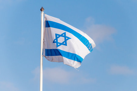 Flag of Israel on flagpole waving in the wind.のeditorial素材