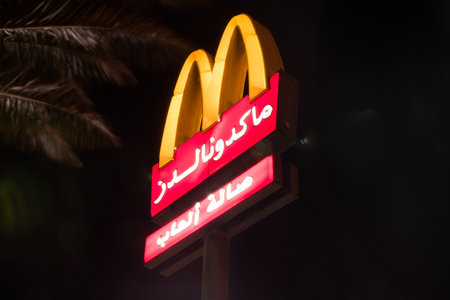 Aqaba, Jordan - February 7, 2019: McDonald's logo with Arabic language inscription.のeditorial素材