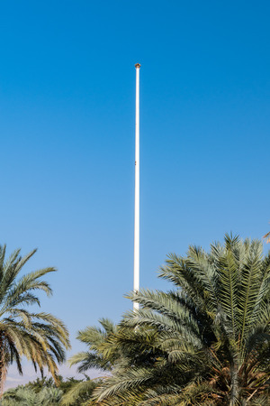 The Aqaba Flagpole over palms in Aqaba, Jordan.の写真素材