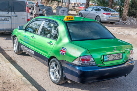 Aqaba, Jordan - February 8, 2019: Green Mitsubishi Lancer GLX Taxi car in Aqaba city.のeditorial素材