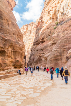 Petra, Jordan - February 8, 2019: Tourists between rocks in the ancient city of Petra, Jordan. Petra is a historical and archaeological city in southern Jordan.のeditorial素材