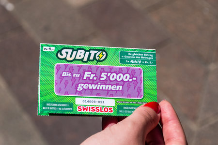 Lugano, Switzerland - June 1, 2019: Subito SWISSLOS lottery scratch card in woman hand.のeditorial素材