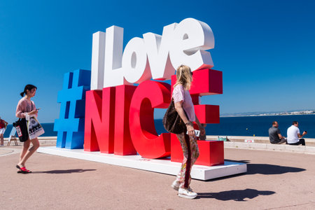 Nice, France - June 2, 2019: Hashtag symbol I love Nice with walking poeple.