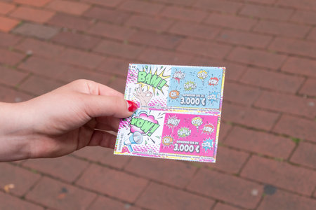 Hanover, Germany - June 8, 2019: Lotto lottery scratch card in woman hand.のeditorial素材