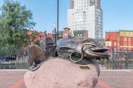 Kaliningrad, Russia - August 5, 2019: View of Bronze catfish sculpture on the stone on embankment of the Pregolya River.のeditorial素材