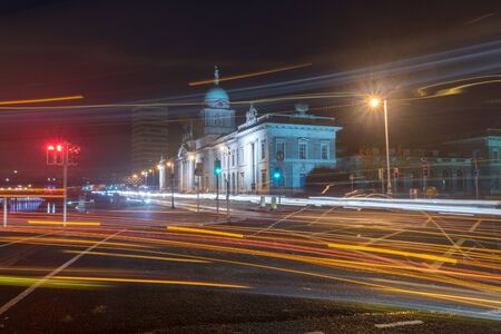 Blurred motion long exposure lines light of car headlamps headlights at night. Street view of city center of Dublin with The Custom House in background in Dublin, Ireland.の写真素材