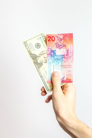 20 USD and 20 CHF banknotes held in hand.の写真素材