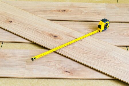 Metal measuring tape on floor panels when laying them on the floor.の写真素材