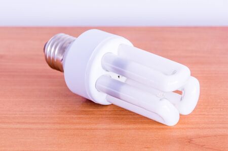 Compact fluorescent lamp on wooden table.の写真素材