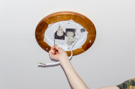 Pruszcz Gdanski, Poland - February 7, 2020: Man installing ceiling lamp.のeditorial素材