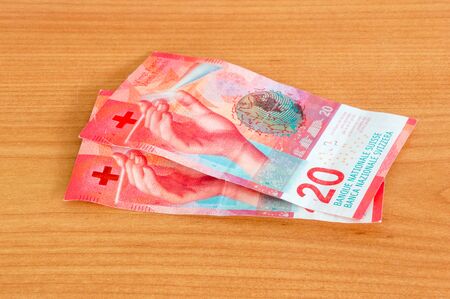 Swiss Francs (20 CHF) banknotes on wooden table.の写真素材