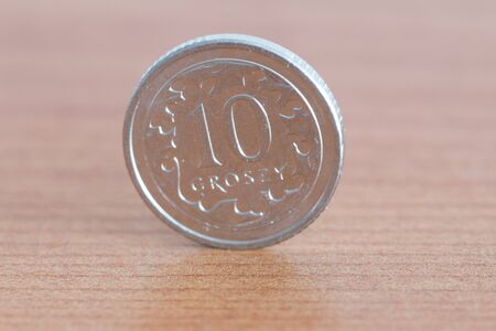 Polish 10 groszy coin on wooden table.の写真素材