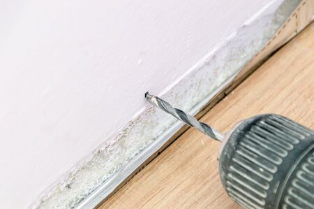 Beginning of drilling in the wall. A close up on a drill.の写真素材
