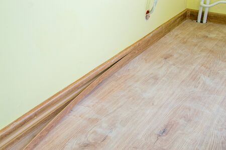 Installing decor strip of floor plastic skirting boards.の写真素材