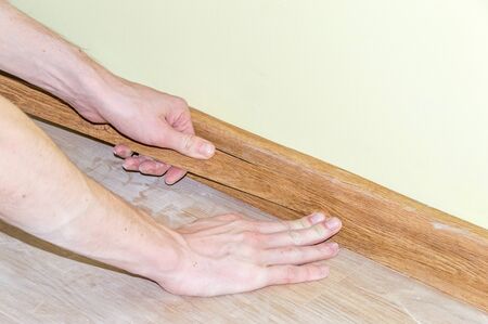 Man hands intall floor plastic skirting boards.の写真素材