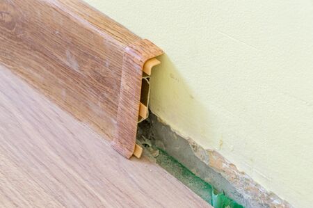 Installation of floor plastic skirting boards. Close-up on plastic connector of floor plastic skirting.の写真素材