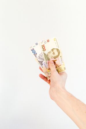 Man hand holding 100 and 500 Ukrainian hryvnia banknotes (UAH).の写真素材