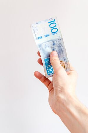 100 Swedish krona banknote in hand. Swedish bank note with portrait of Greta Garbo.の写真素材