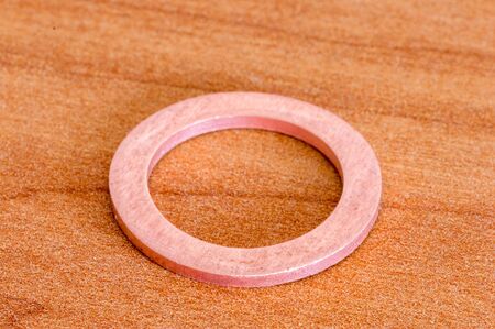 Copper screw washer on wooden table.