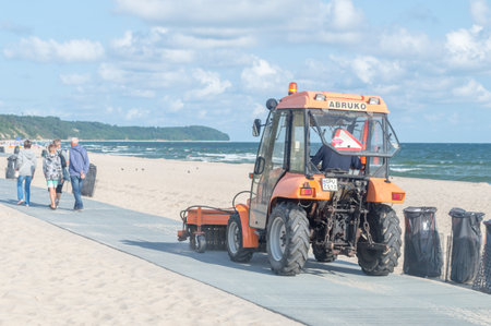 Wladyslawowo, Poland - July 21, 2021: Tractor is sweeping alley along coast of Baltic Sea.のeditorial素材