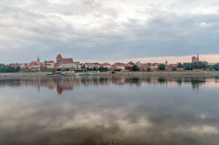Morning view of panoramic view on Old town of Torun city walls and reflection in Vistula river.