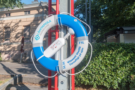 Turku, Finland - August 6, 2021: Lifebuoy on river bank of Aurajoki river.のeditorial素材