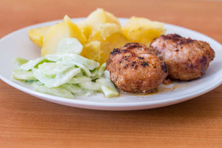 Ground cutlets with mizeria and potatoes.
