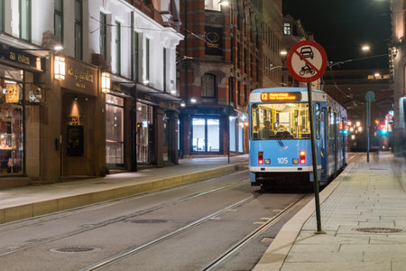 Oslo, Norway - September 24, 2021: Blue tram standing at tram stop at night.のeditorial素材