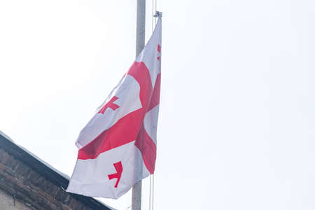 The Georgian national flag is a white rectangle, with a large red cross in its central portion touching all four sides of the flag.の写真素材