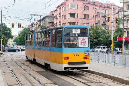 Sofia, Bulgaria - June 6, 2022: Blue and yellow tram on tram stop in Sofia.の写真素材